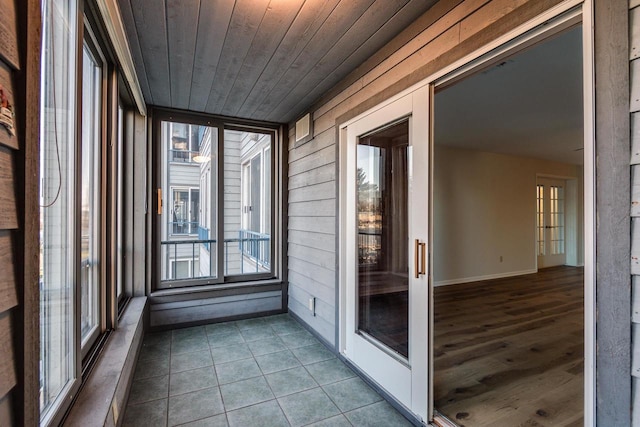 unfurnished sunroom with wood ceiling