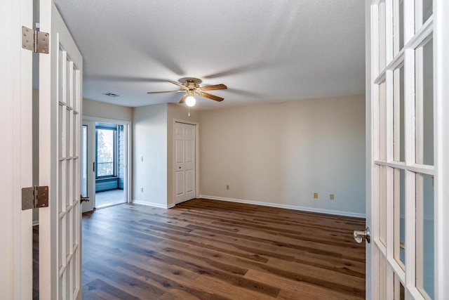 empty room featuring a textured ceiling, dark hardwood / wood-style flooring, and ceiling fan