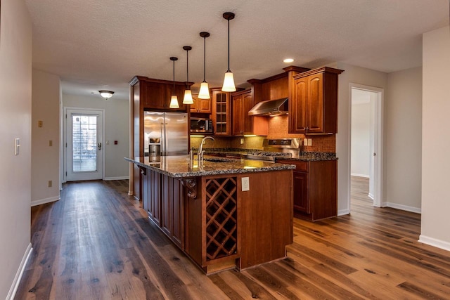 kitchen with dark hardwood / wood-style floors, stainless steel appliances, hanging light fixtures, and range hood