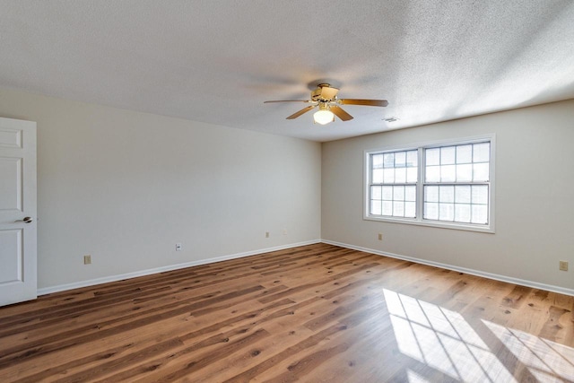 empty room with wood-type flooring and a textured ceiling