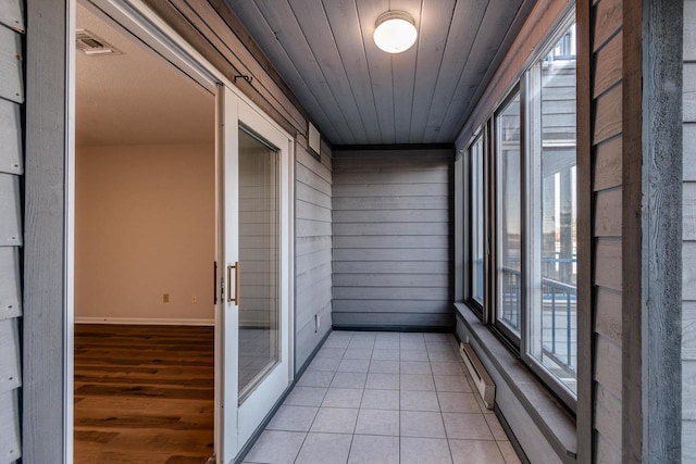 unfurnished sunroom featuring a baseboard heating unit