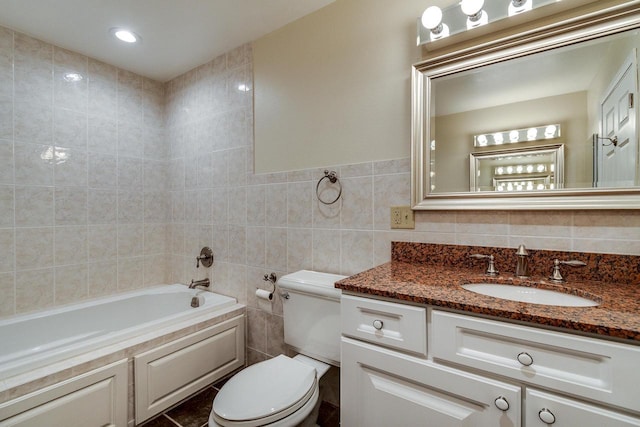 bathroom featuring a bathtub, vanity, tile walls, and toilet