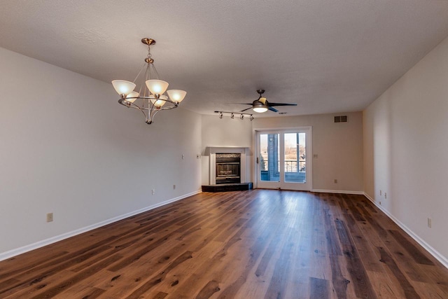 unfurnished living room with ceiling fan with notable chandelier, dark hardwood / wood-style flooring, and a textured ceiling