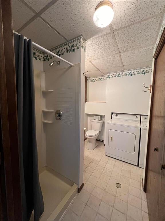 bathroom with tile patterned flooring, washing machine and dryer, toilet, and walk in shower