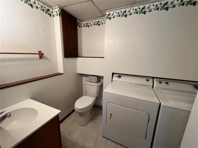 bathroom with vanity, a paneled ceiling, toilet, and washer and clothes dryer