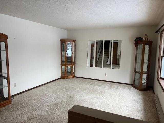 carpeted spare room with a textured ceiling