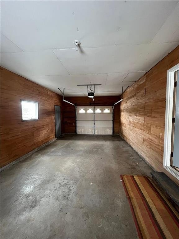 garage featuring wooden walls and a garage door opener