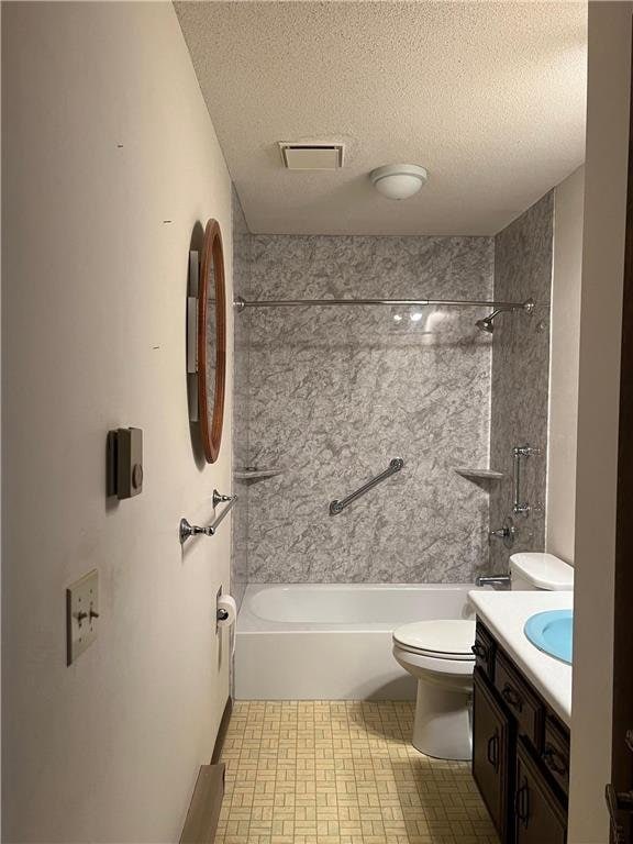 full bathroom with vanity, tiled shower / bath combo, a textured ceiling, and toilet