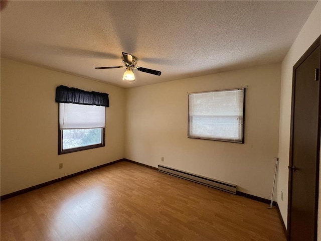 unfurnished room with wood-type flooring, a textured ceiling, a baseboard radiator, and ceiling fan