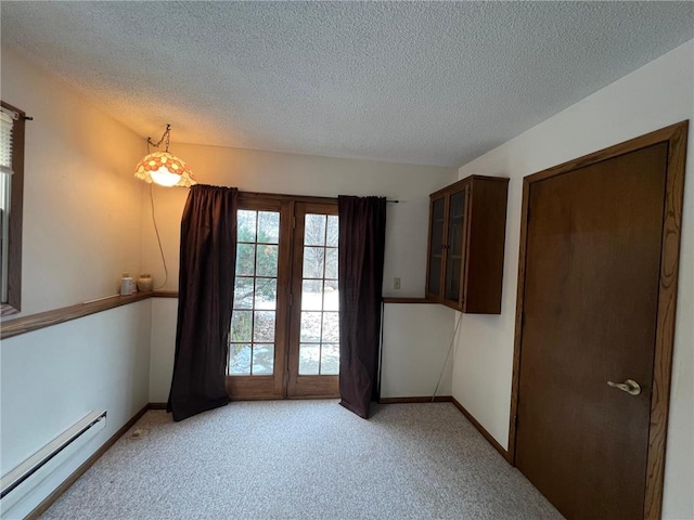 carpeted empty room with a baseboard radiator and a textured ceiling