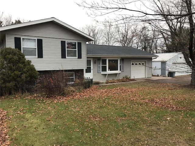 split level home featuring a garage and a front lawn