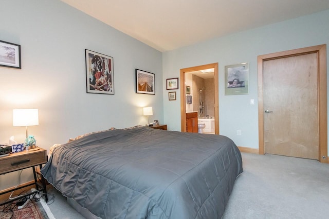 bedroom featuring light carpet and connected bathroom