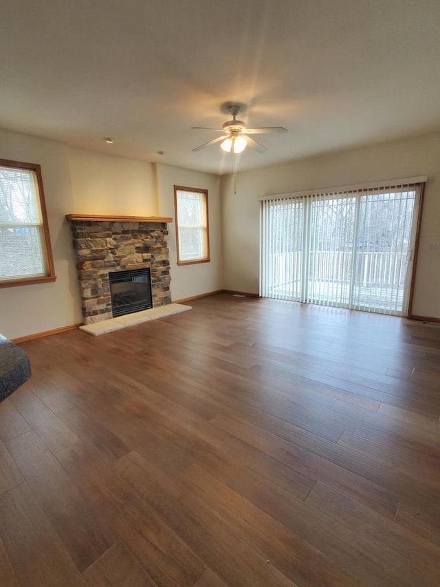 unfurnished living room featuring a fireplace, dark hardwood / wood-style flooring, and ceiling fan