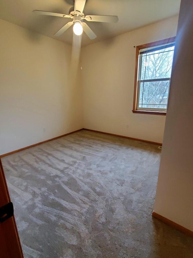 spare room with ceiling fan and carpet