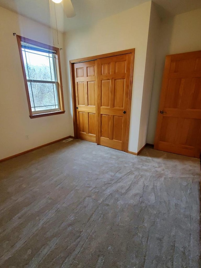 unfurnished bedroom featuring ceiling fan, light carpet, and a closet