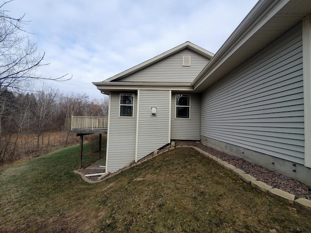 view of home's exterior with a wooden deck and a yard