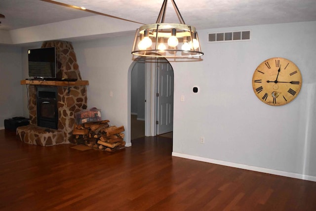 unfurnished dining area with a textured ceiling, hardwood / wood-style flooring, and a stone fireplace