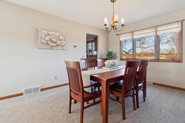 dining space with a notable chandelier and carpet floors