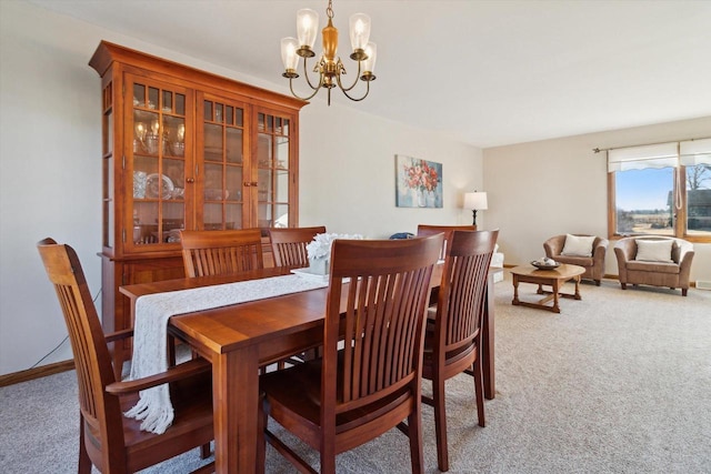 carpeted dining area featuring a notable chandelier