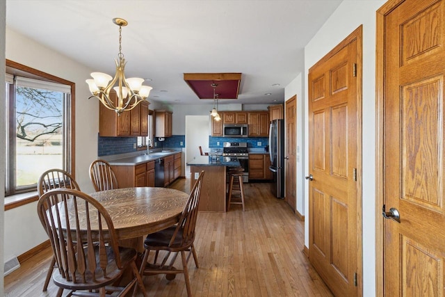 dining area featuring sink, an inviting chandelier, and light wood-type flooring