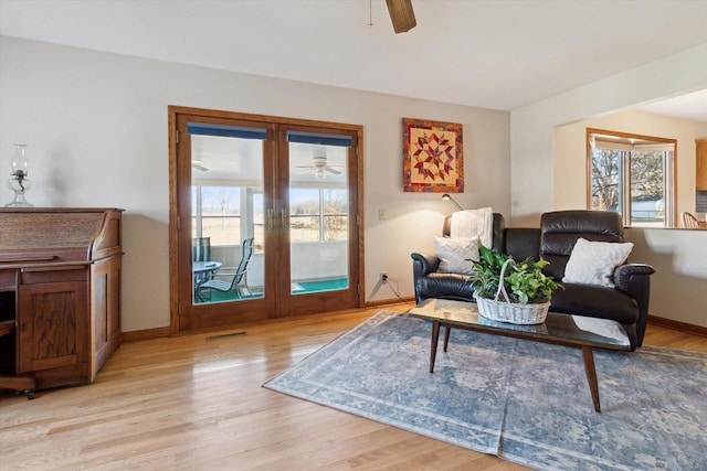 living room featuring ceiling fan, light hardwood / wood-style floors, and french doors