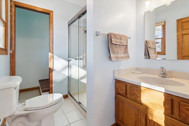 bathroom featuring vanity, toilet, an enclosed shower, and tile patterned flooring