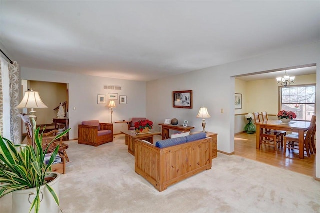 carpeted living room with a notable chandelier