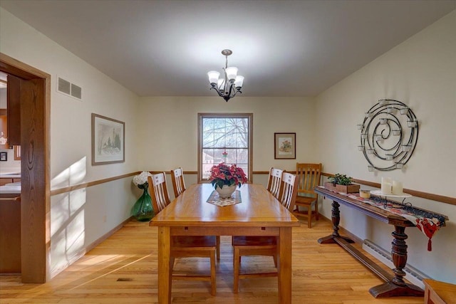 dining room featuring a chandelier, light hardwood / wood-style floors, and baseboard heating