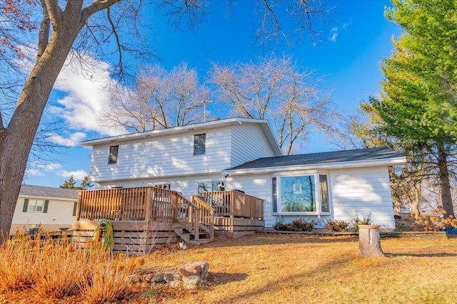 rear view of property featuring a yard and a deck