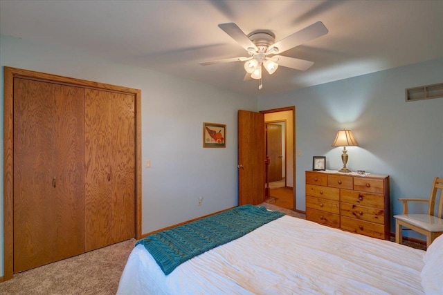 bedroom featuring ceiling fan, a closet, and light colored carpet