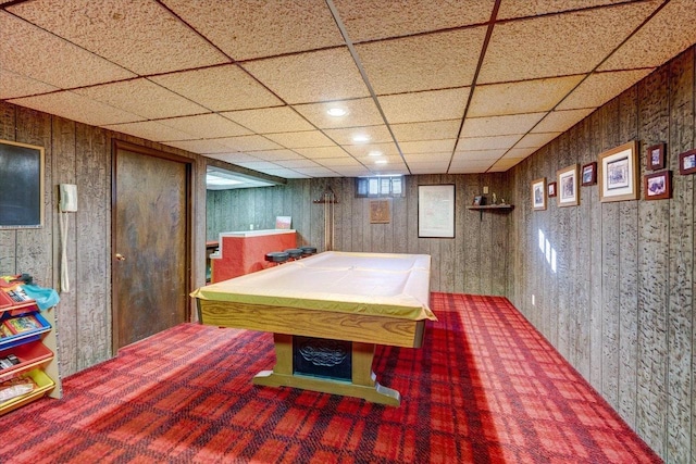 rec room with carpet, a paneled ceiling, wood walls, and pool table