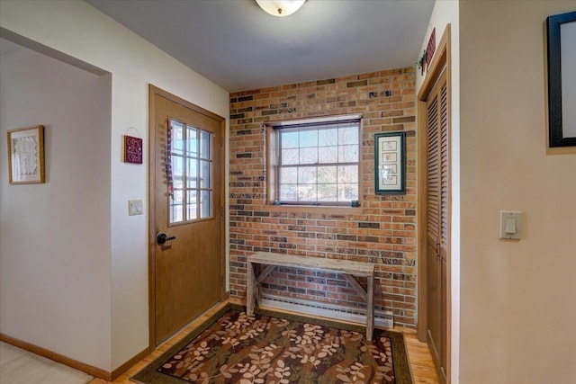 entryway featuring brick wall and light wood-type flooring