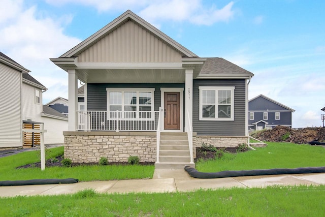 view of front of home with covered porch and a front lawn