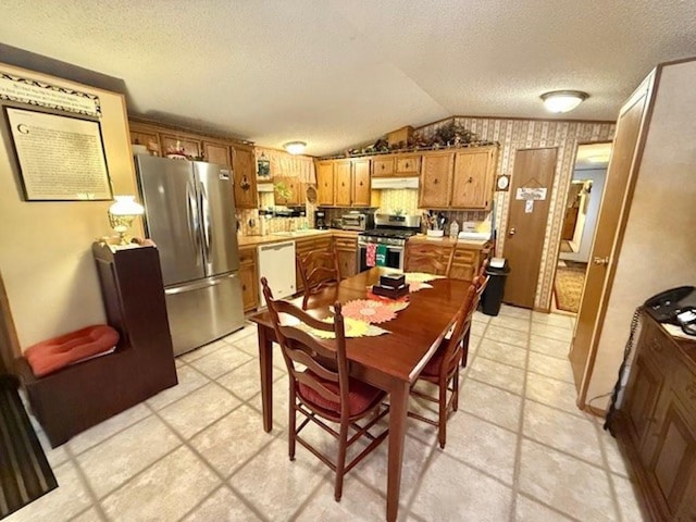 dining area with light tile patterned floors, a textured ceiling, and vaulted ceiling