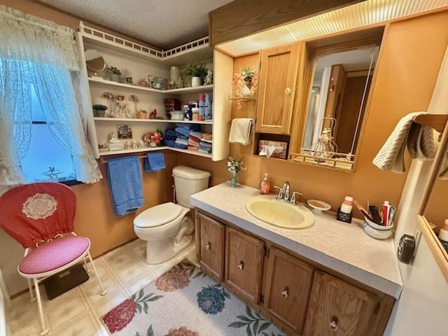 bathroom featuring vanity, a textured ceiling, and toilet