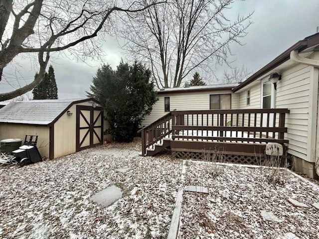 snow covered deck featuring a storage unit