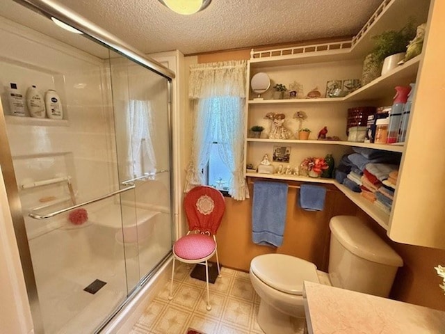 bathroom featuring vanity, toilet, a textured ceiling, and walk in shower