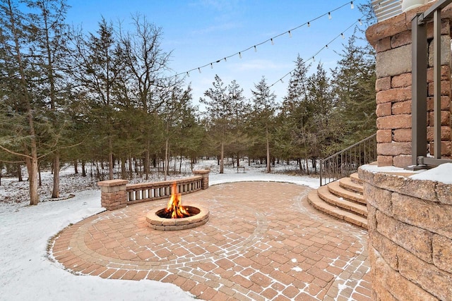 view of home's community featuring an outdoor fire pit and a patio area