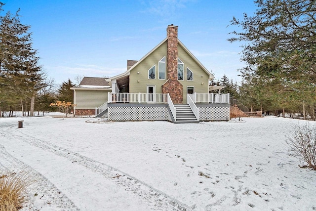 snow covered house with a wooden deck