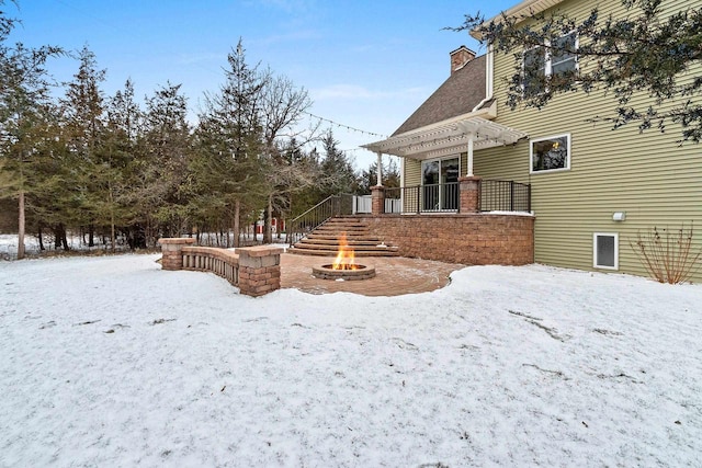 yard layered in snow featuring an outdoor fire pit