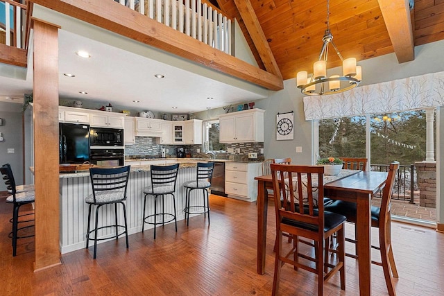 interior space featuring white cabinetry, dark hardwood / wood-style floors, a notable chandelier, pendant lighting, and black appliances