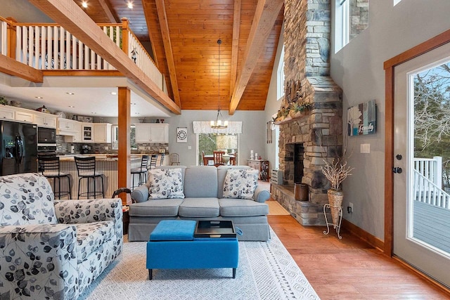 living room with light wood-type flooring, high vaulted ceiling, beamed ceiling, wooden ceiling, and a fireplace