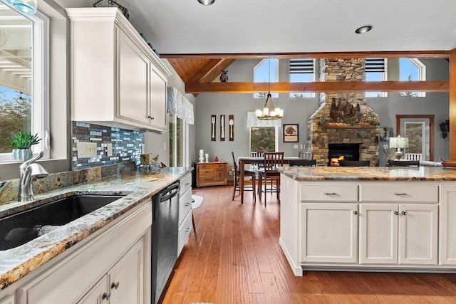 kitchen featuring a fireplace, white cabinetry, and sink