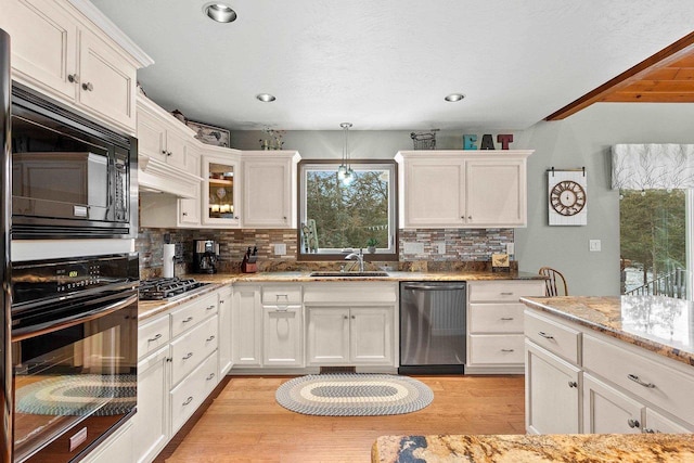 kitchen with white cabinets, sink, tasteful backsplash, and black appliances