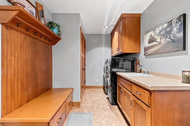 laundry area featuring washer and clothes dryer, cabinets, and sink