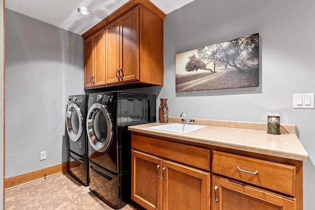 washroom featuring washer and dryer, sink, and cabinets