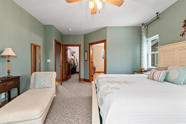 carpeted bedroom featuring ceiling fan, a walk in closet, ensuite bathroom, and a closet