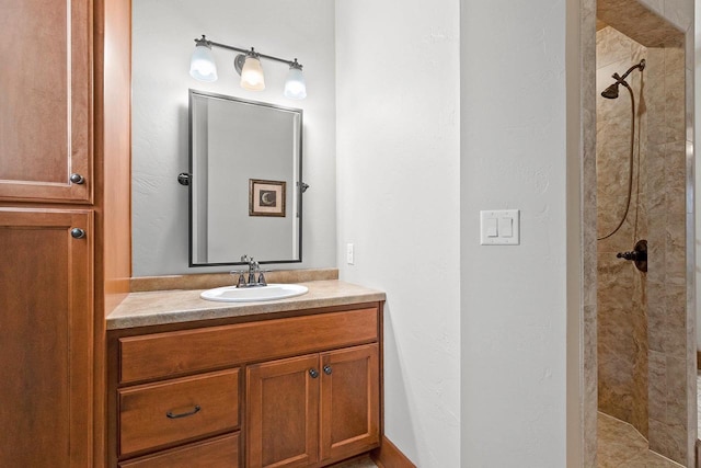 bathroom with vanity and a tile shower