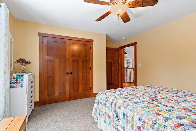 bedroom with ceiling fan, light colored carpet, and a closet