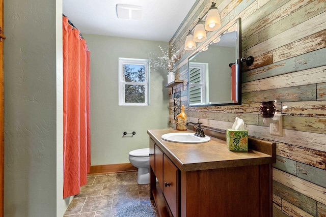 bathroom featuring vanity, toilet, decorative backsplash, and wooden walls